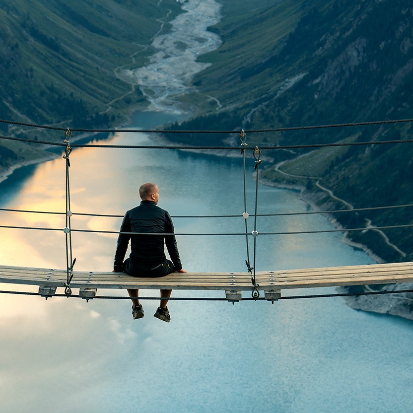 A person sitting on a bridge